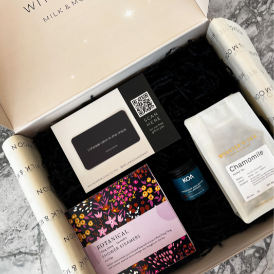 Open box containing various skincare products with visible branding on a marble surface.
